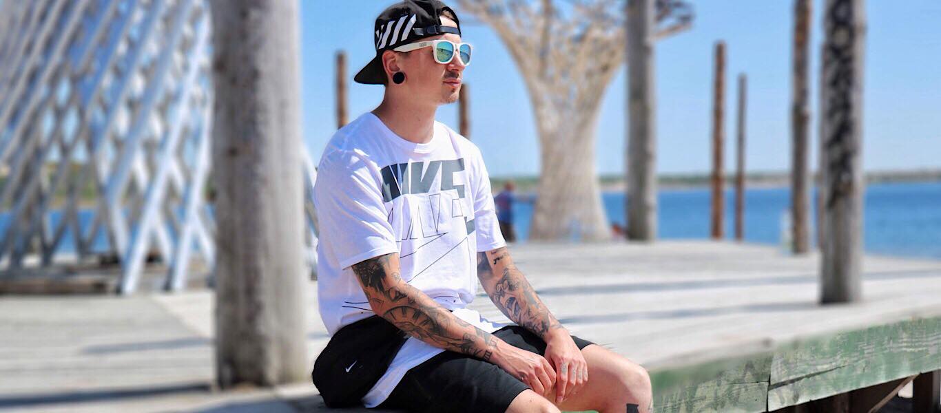 Sitzender Mann mit Nike Shirt und Nike Air Force One Schuhen